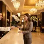 Réceptionniste remettant une clé à une cliente dans un luxueux hall d'hôtel