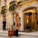 Femme avec valise devant hôtel de luxe parisien