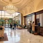 Réception élégante d'hôtel avec lustre, marbre et personnel