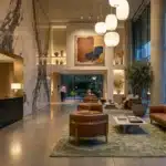 Hall d'accueil moderne avec marbre, mobilier cognac et grandes baies vitrées