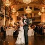 Couple dansant dans une salle de bal luxueuse décorée de fleurs blanches