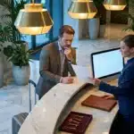 Réceptionniste et homme d'affaires à la réception d'hôtel luxe
