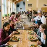 Enfants mangeant ensemble à la cafétéria scolaire avec personnel