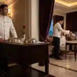 Serveurs en uniforme blanc servant le dîner en suite hôtelière