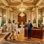Couple élégant à la réception d'un palace avec lustres dorés