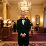 Homme en smoking dans un palace ornementé avec lustres et colonnes dorées