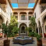 Cour intérieure marocaine avec colonnes, fontaine et arcades